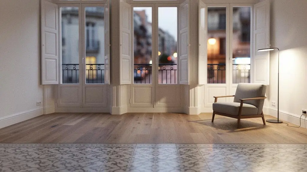 Salón de un piso reformado en un edificio clásico español donde la luz natural y una distribución abierta amplían visualmente el espacio útil.