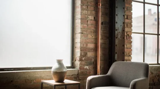 Loft de estilo industrial en España con tubería de cobre vista y textura de ladrillo convertidas en elementos decorativos de autor