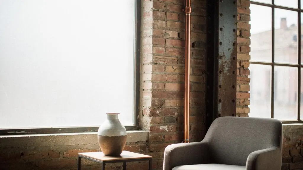 Loft de estilo industrial en España con tubería de cobre vista y textura de ladrillo convertidas en elementos decorativos de autor